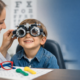 Smiling child receiving a gentle eye exam from an optometrist using a phoropter in a child-friendly clinic