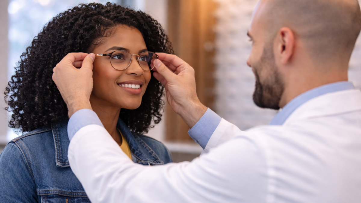 Optician adjusting loose eyeglasses frame for better fit in an optical clinic
