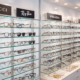 Designer and everyday eyeglasses displayed together in a modern optical store showing variety of styles and brands